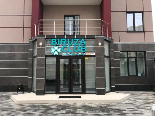 a building with a blue sign on the front of it at Biruza Club in Svyatopetrivske