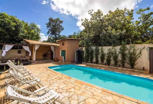 a villa with a swimming pool and lounge chairs at Pousada Pepalantus in Serra do Cipo