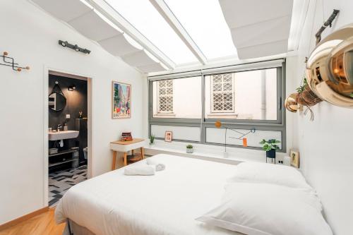 une chambre avec un grand lit blanc et une fenêtre dans l'établissement Amazing Apartment Notre Dame Boulevard St-Germain - 4 Bedrooms, à Paris