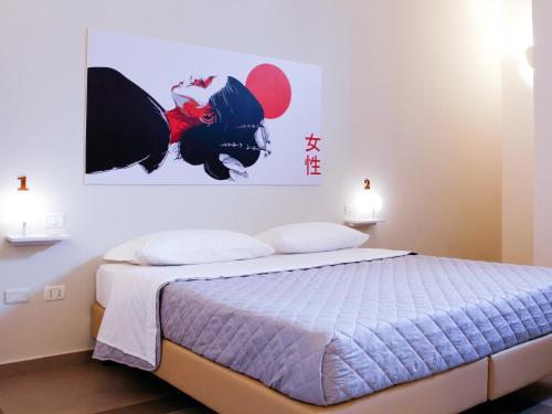 1 dormitorio con 1 cama con una pintura en la pared en Lobby Collective Hostel - Lecce en Lecce