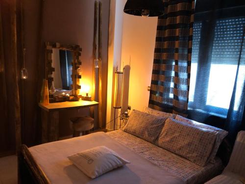 a bedroom with a bed with a mirror and a window at Relux Suite in Agios Nikolaos