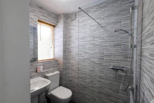 a bathroom with a shower and a toilet and a sink at Treetops in Gatehouse of Fleet