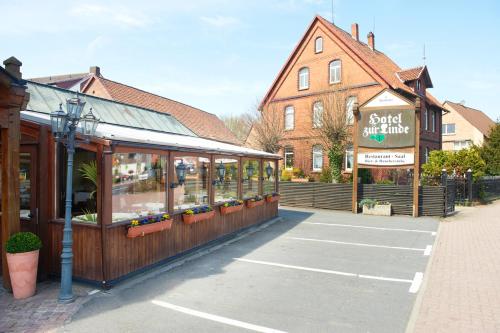 a store in a parking lot next to a building at Hotel Restaurant zur Linde in Pattensen