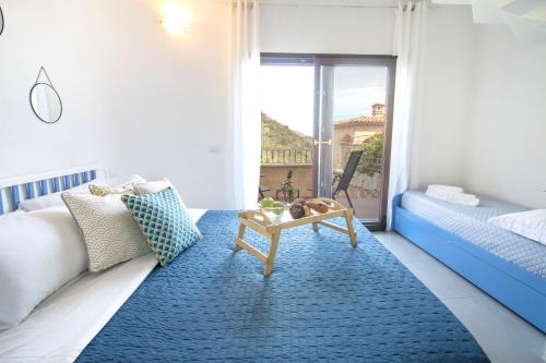 una camera con letto e tappeto blu di Homey Experience - Emerald Valley Apartment a Porto Cervo