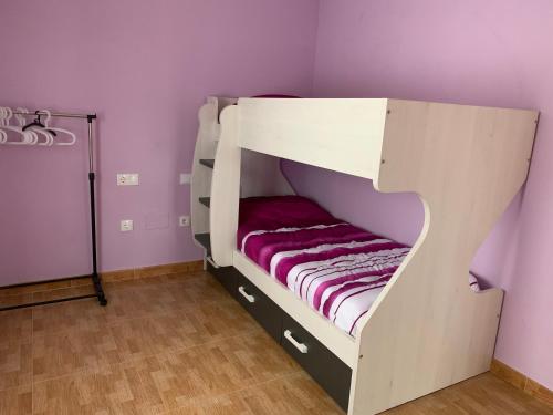 Narón的住宿－San Saturnino，紫色墙壁客房内的双层床