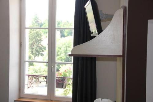a kitchen with a large window with a view at Logis Hôtel de France restaurant le Lucullus in Montmorillon