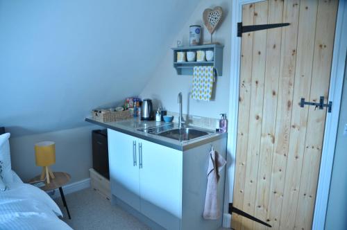 a kitchen with a sink in a blue room at Foxglove retreat in Woodhall Spa