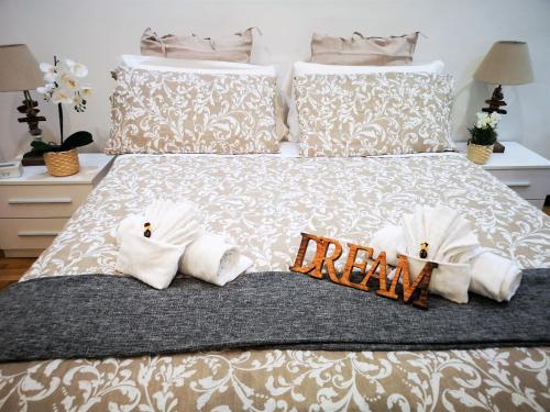 a bed with two towels and a dream sign on it at Have A Nice Holiday - Luxury Rooms in Rome
