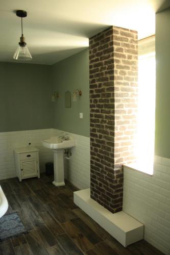 a bathroom with a sink and a brick pillar at Le clos Darwin - chambres d'hôtes in Brin-sur-Seille