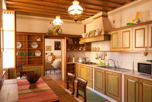 una cocina con armarios de madera, mesa y sillas en Casa Archè, en Feltre