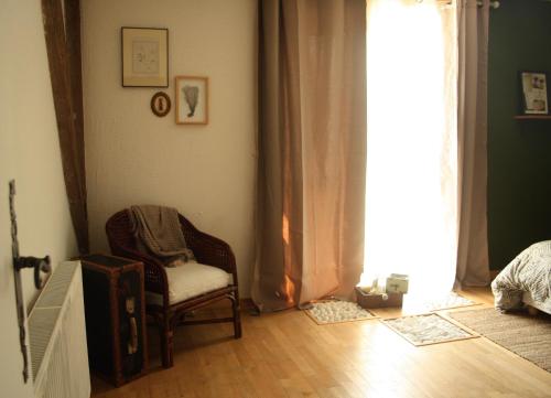 a living room with a chair and a window at Le clos Darwin - chambres d'hôtes in Brin-sur-Seille