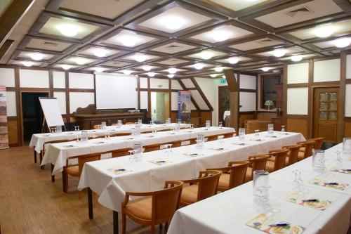 a large room with white tables and chairs at Hotel Restaurant zur Linde in Pattensen