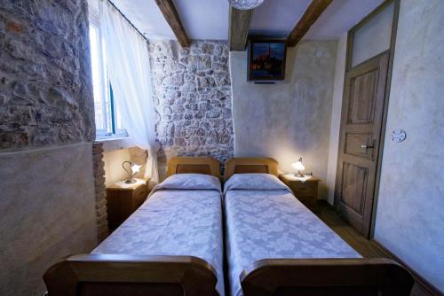 two beds in a small room with a window at House Trevisol in Rovinj