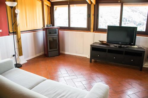a living room with a couch and a television at Podere Scoglio d'Oro in Pescia