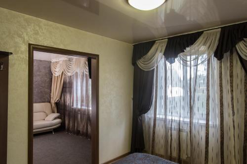 a room with a window and a couch and a mirror at Отель Шоколад in Barnaul