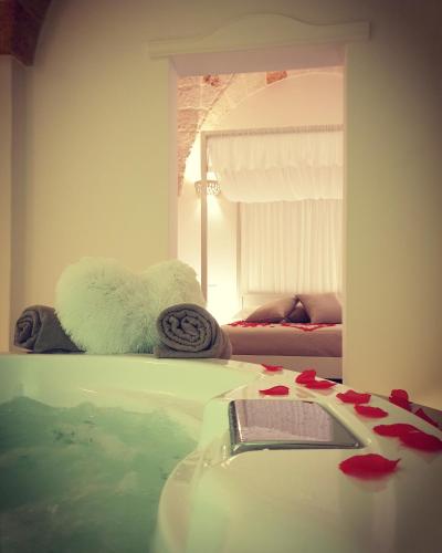 a room with a tub of water and a mirror at Christian's Suites & Spa in Fasano