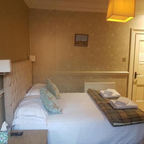 a bed in a room with two pillows on it at Fox and Pheasant Inn in Armathwaite