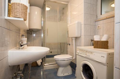 La salle de bains est pourvue d'un lavabo et d'un lave-linge. dans l'établissement Studio apartments Malú, à Pula