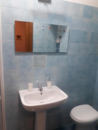 a bathroom with a sink and a toilet and a mirror at Casa Rosy.S in Pozzuoli