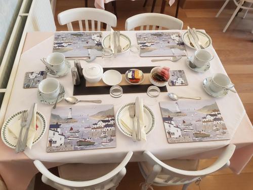 einen weißen Tisch mit Tellern und Küchenutensilien darauf in der Unterkunft Rosemead Guest House in Paignton