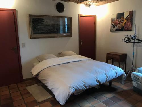 ein Schlafzimmer mit einem großen Bett in einem Zimmer in der Unterkunft Le charme de l’Estroit in Mettet