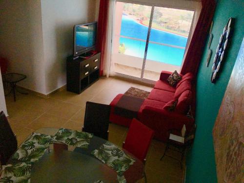 sala de estar con sofá rojo y TV en El Eden en Cancún incluye lancha, en Cancún
