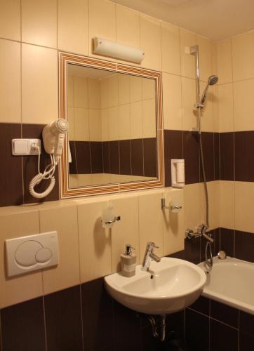 a bathroom with a sink and a mirror and a tub at Penzion Set in Košice