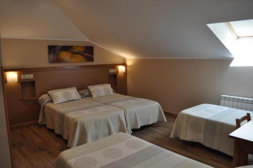 a hotel room with two beds and a window at La Chopera in Ribadesella
