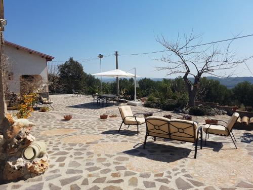 a patio with chairs and a table and an umbrella at Borgo Santa Lucia in Cropani