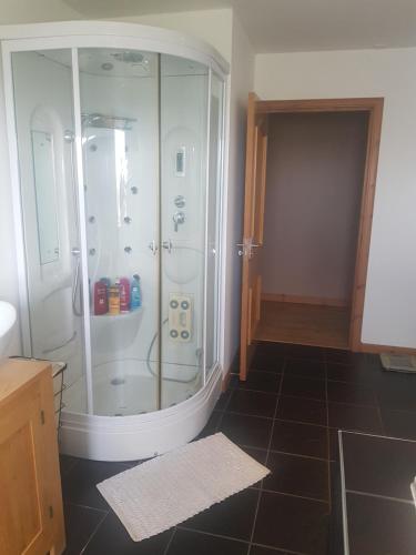 bagno con doccia e pavimento piastrellato nero. di Valhalla B&B a Bowermadden