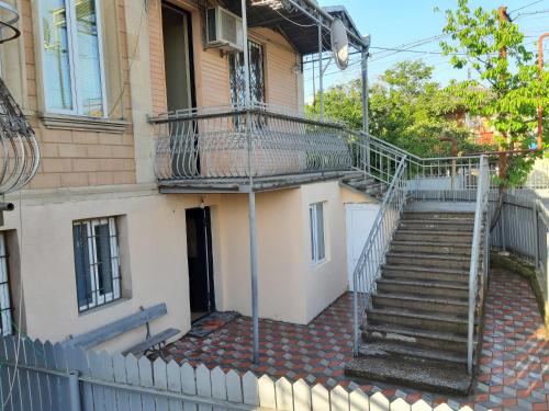 uma escada que leva até um edifício com uma varanda em Guest House Luka em Kutaisi