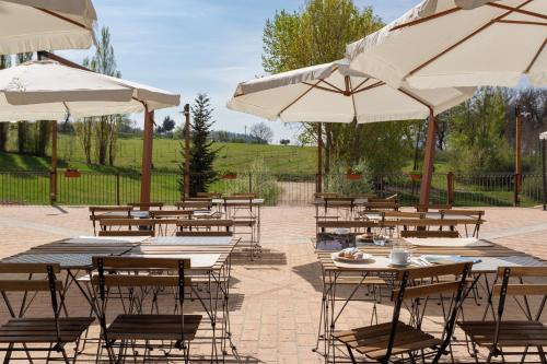 a group of tables and chairs with umbrellas at GH Borgo Pulciano Agriturismo in Montone