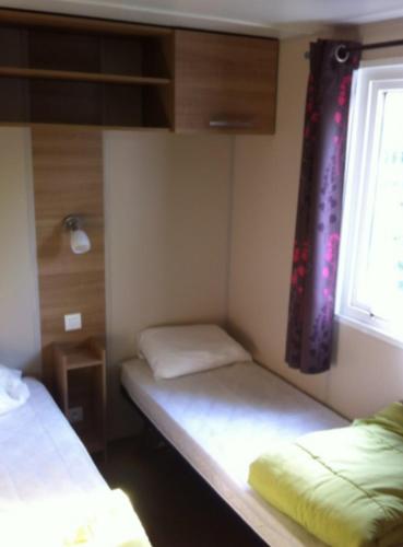 une petite chambre avec deux lits et une fenêtre dans l'établissement GRAND MOBILEHOME PROCHE COMMODITE FO10, à Fréjus