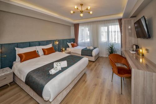 Una habitación de hotel con dos camas y un televisor. en Nika otel & cafe, en Estambul