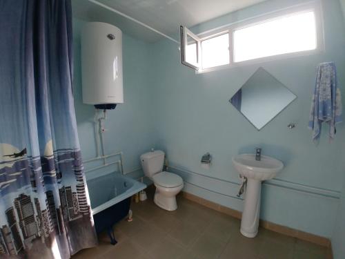 a bathroom with a toilet and a tub and a sink at Tatev Guest House in Tatʼev
