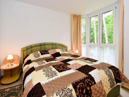 a bedroom with a quilt on a bed with a window at Ferienwohnung 8-3 in Baabe