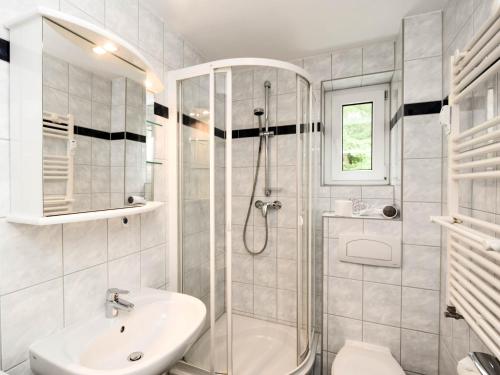a white bathroom with a shower and a sink at Ferienwohnung 8-3 in Baabe