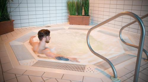 a man in a jacuzzi in a bath tub at Hotel Killarney in Killarney