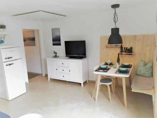 ein Wohnzimmer mit einem kleinen Tisch und einem TV in der Unterkunft HEIMATGLÜCK Winterberg in Winterberg