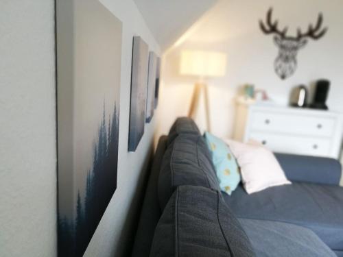 ein Schlafzimmer mit Sofa und Bildern an der Wand in der Unterkunft HEIMATGLÜCK Winterberg in Winterberg