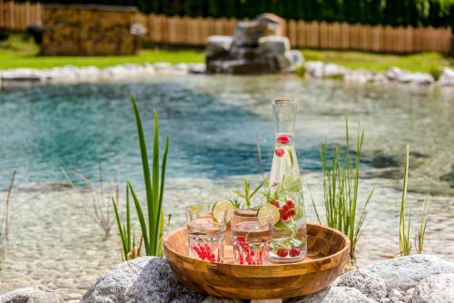 a bowl with glasses and a bottle on top of a pool at Das Kleinarl in Kleinarl