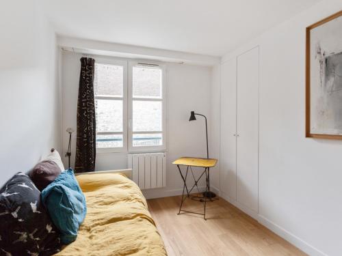 パリにあるWelkeys - douai Apartmentのベッドルーム1室(ベッド1台、窓、テーブル付)