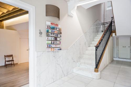 a staircase in a home with white walls and white floors at BcnStop Parc Güell in Barcelona