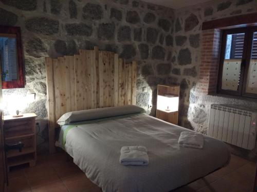 a bedroom with a bed with two towels on it at Casa Luz in Ávila