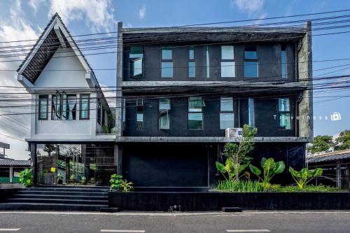 a large black and white building with a lot of windows at Trat 101 Hotel - SHA Certified in Trat