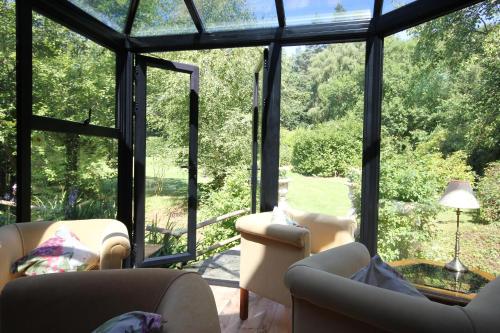 a living room with chairs and a large glass window at Felbrigg Lodge Bed And Breakfast in Aylmerton