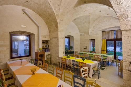 a restaurant with tables and chairs in a room at Masseria Ferri in Ostuni