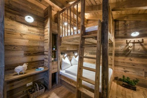 a bunk bed in a log cabin bedroom with wooden walls at Das Kleinarl in Kleinarl
