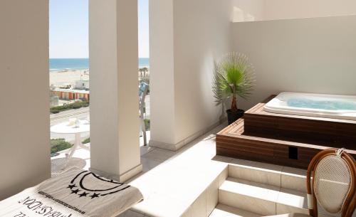 a balcony with a jacuzzi tub in a room at Hotel Ambassador in Rimini