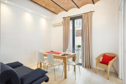 a dining room with a table and chairs and a couch at BcnStop Parc Güell in Barcelona